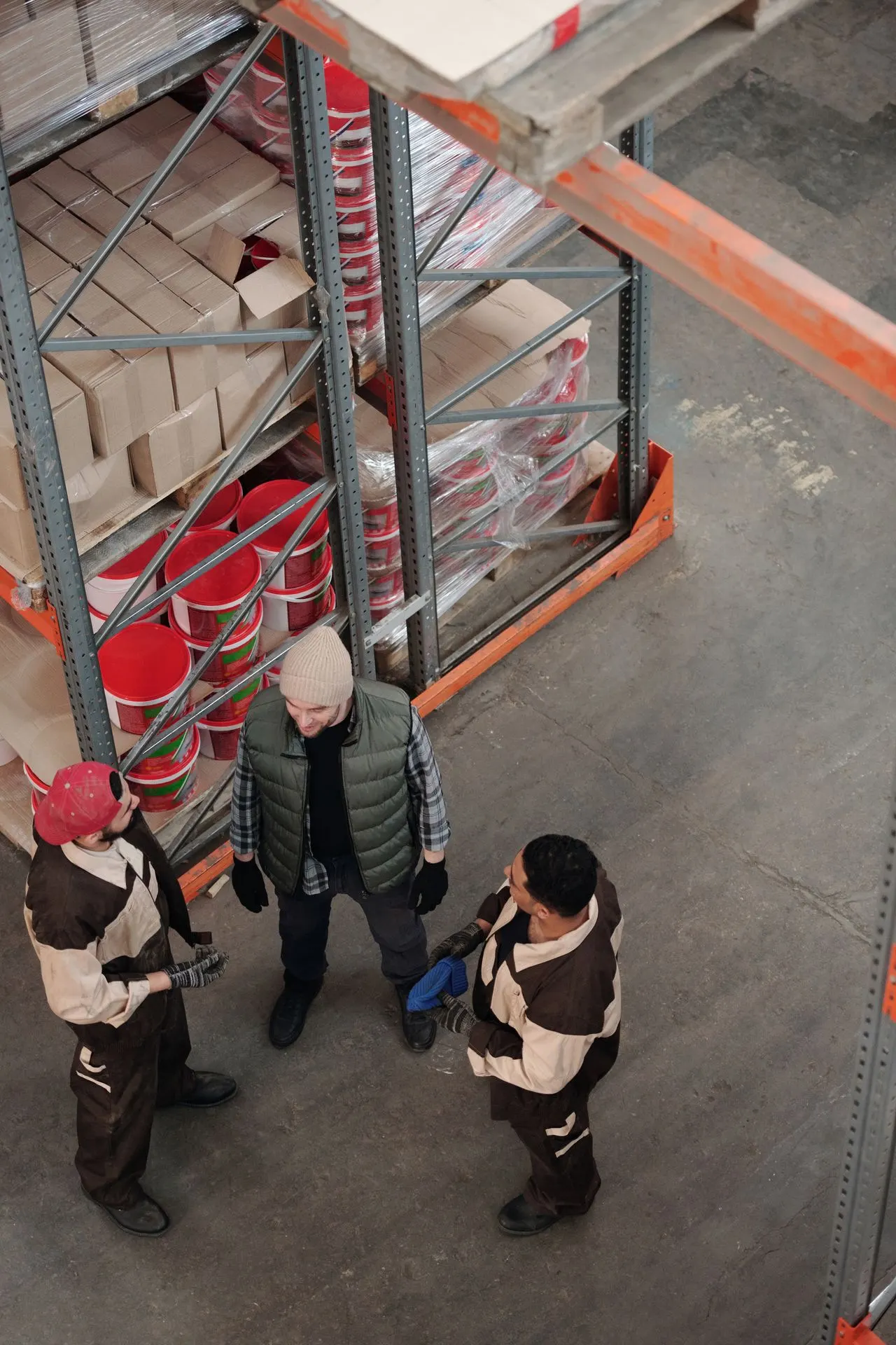 Medewerkers overleggen in een magazijn; tijdelijk sfeerbeeld.