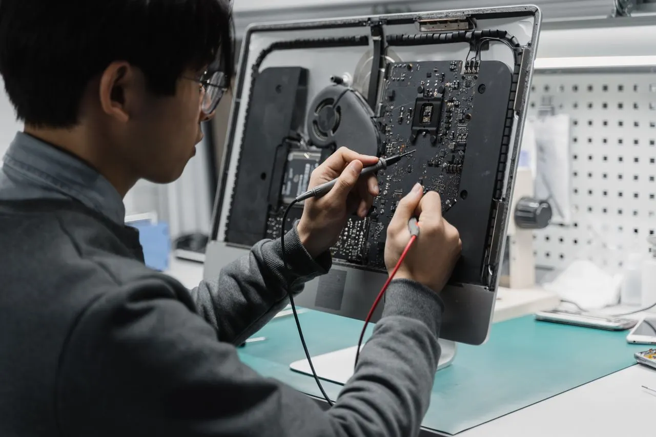 Technicus werkt aan computerhardware; tijdelijk sfeerbeeld.